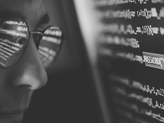 Man looks at screen with code